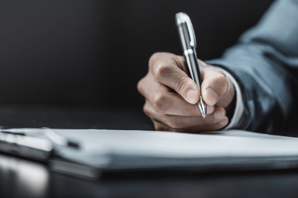 Image of man using his spy pen to write at work