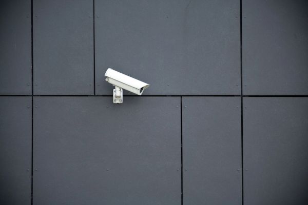 image of white security camera on a dark grey building